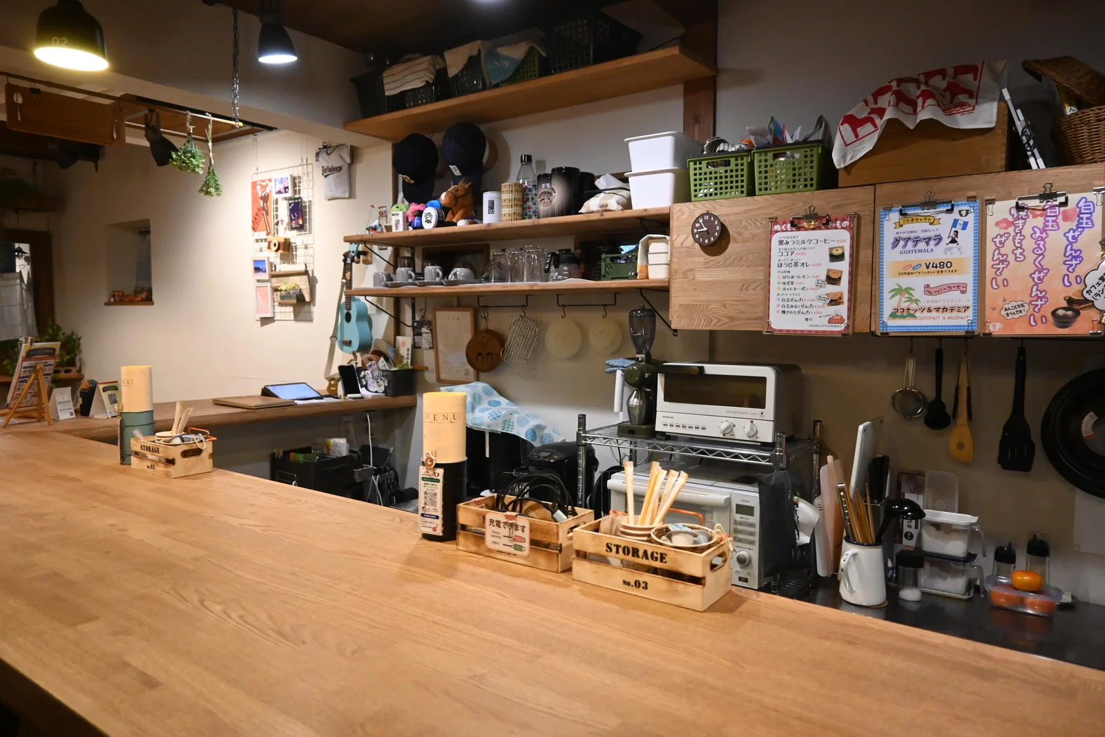 カフェこだまのカウンター越しに見える食器棚と厨房